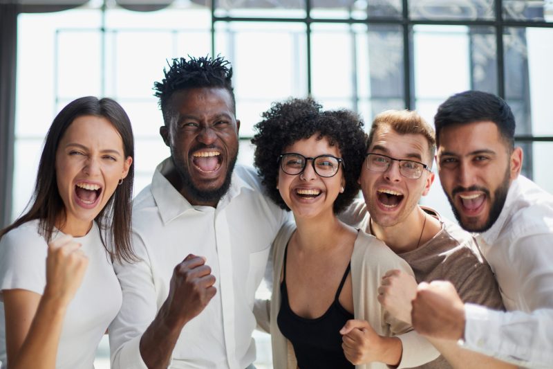 Portrait of successful creative business team looking at camera and smiling. Diverse business people standing together at startup.